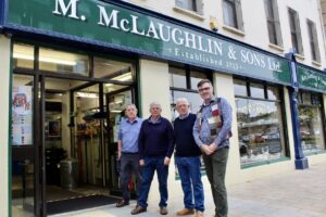 The McLaughlin Brother with Mark Patterson outside the shop front 